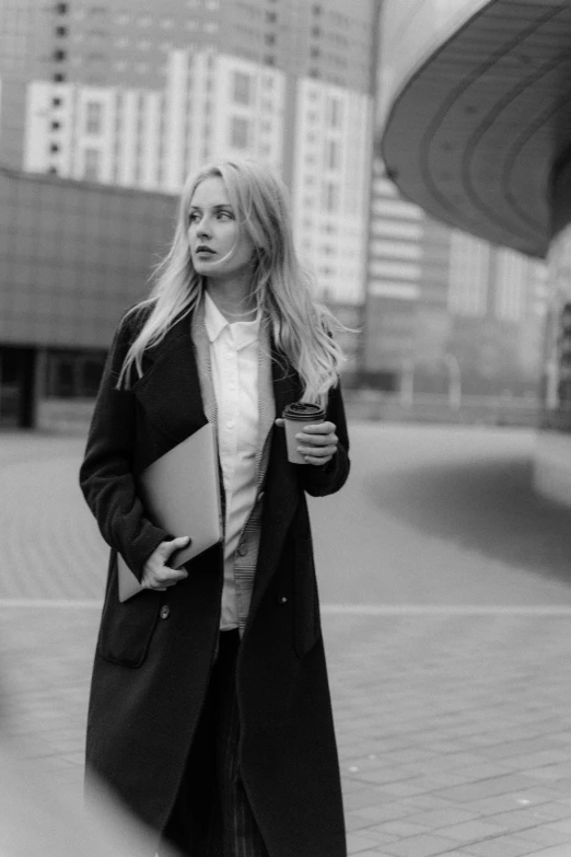 a black and white photo of a woman in a coat, a black and white photo, by Mathias Kollros, pexels, business attire, blonde girl, square, holding notebook