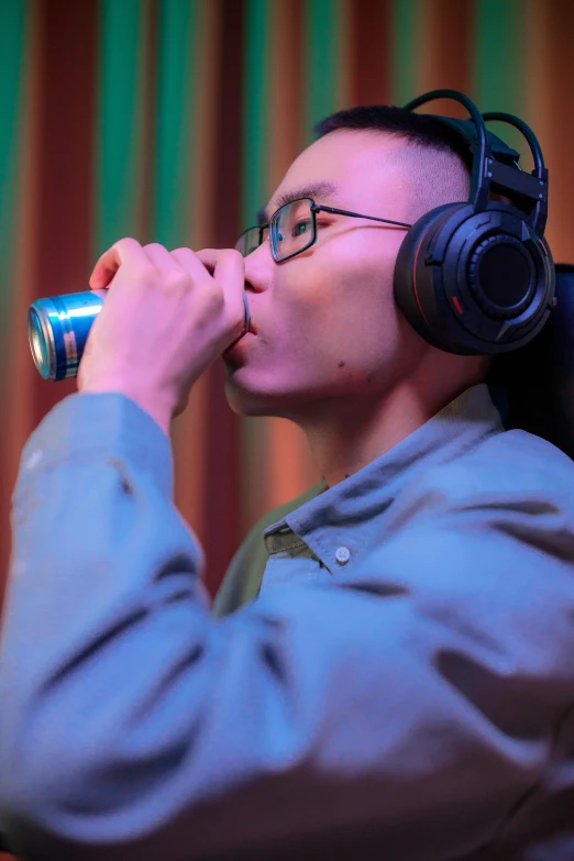 a man wearing headphones drinking from a can, inspired by Song Xu, featured on reddit, press shot, gaming, performance, ashteroth