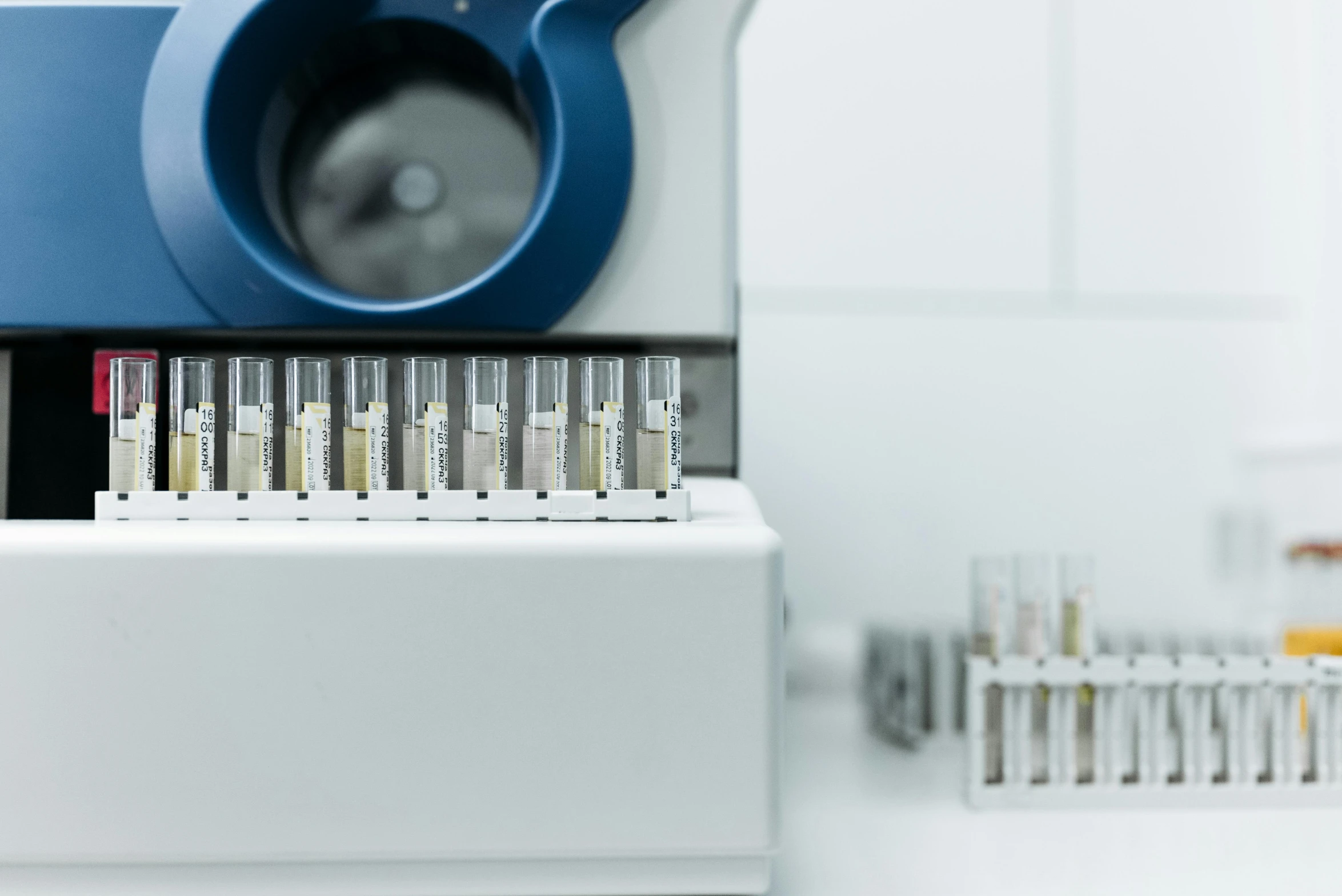 a close up of a machine with a lot of vials in it, a microscopic photo, unsplash, fan favorite, sitting on a lab table, high samples, set against a white background