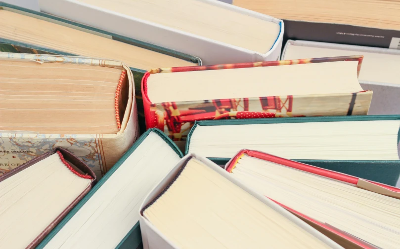 a pile of books sitting on top of a table, birdseye view, full width, multiple stories, school curriculum expert