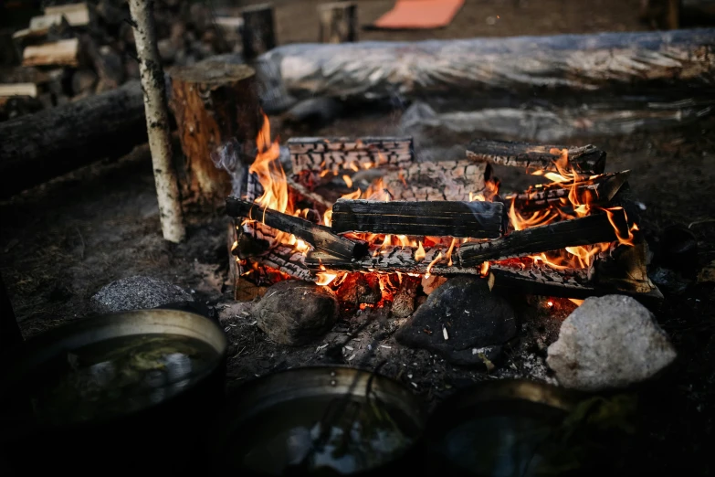 a fire in the middle of a pile of logs, pexels contest winner, hurufiyya, cooking, yuru camp, exterior shot, grey