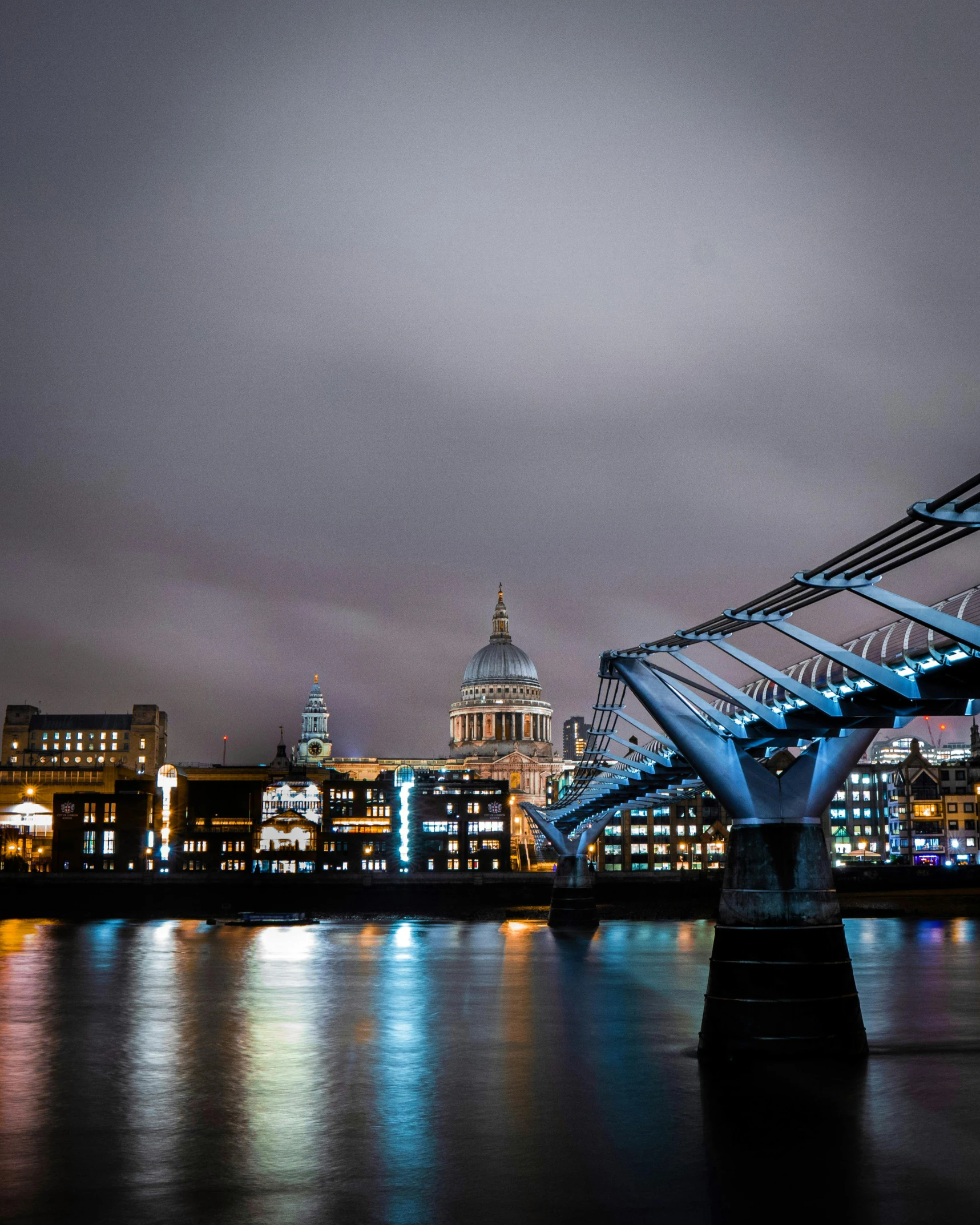 a bridge over a body of water at night, by Christopher Wren, lgbtq, building along a river, trending photo, grey