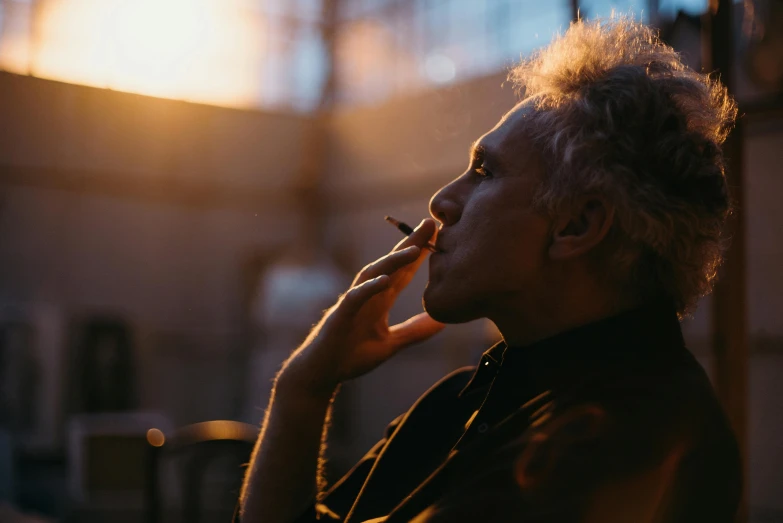 a close up of a person talking on a cell phone, pexels contest winner, visual art, man smokes a cigar, goldenhour, a silver haired mad, man sitting facing away