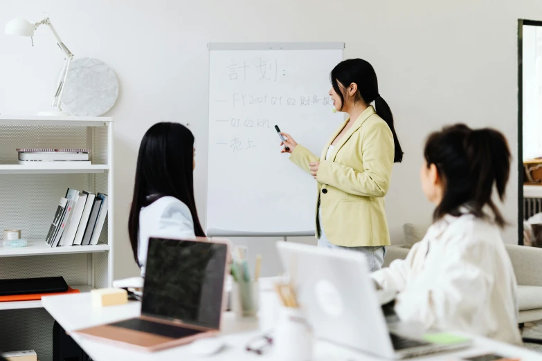 a woman giving a presentation to a group of people, by Jang Seung-eop, trending on pexels, whiteboards, background image, oyama kojima, teacher