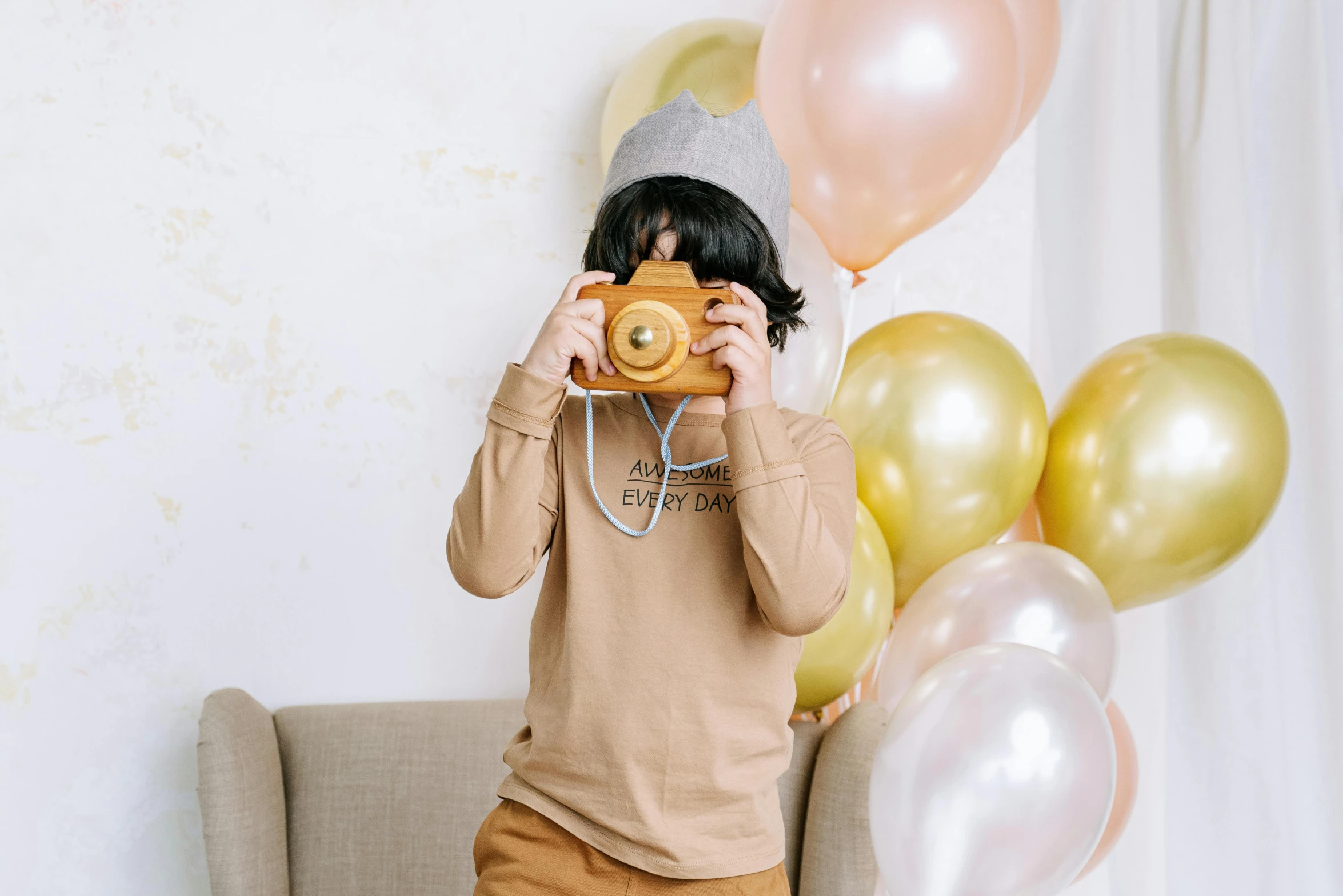 a person taking a picture with a camera, inspired by Sarah Lucas, trending on pexels, party balloons, cute boy, gold shirt, joy ang