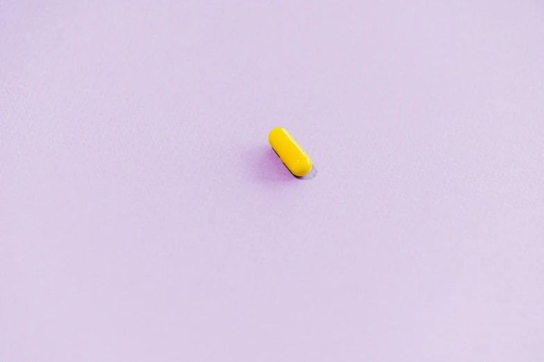 a yellow pill on a purple background, unsplash, postminimalism, violet cockroach, shot with sony alpha 1 camera, on amino, v tuber