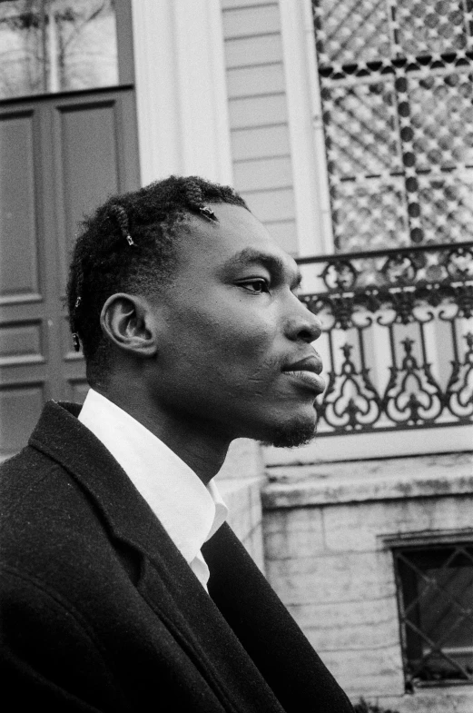 a black and white photo of a man in a suit, inspired by Theo Constanté, childish gambino, circa 1992, looking left, in paris