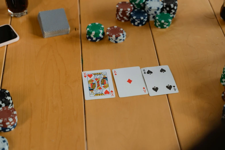 a wooden table topped with poker chips and playing cards, unsplash, high detail photo, realistic photo, pov photo, ingame image