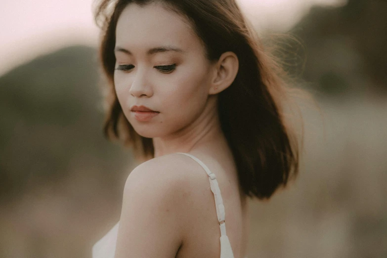 a woman in a white dress standing in a field, trending on pexels, asian beautiful face, wearing a camisole, half body photo, portait image