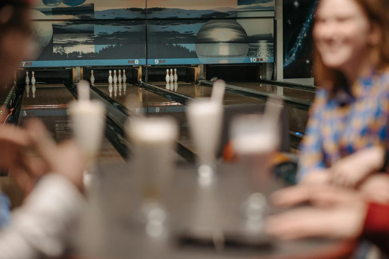 a group of people playing a game of bowling, unsplash, with a drink, aussie baristas, zoomed in, sci-fi themed