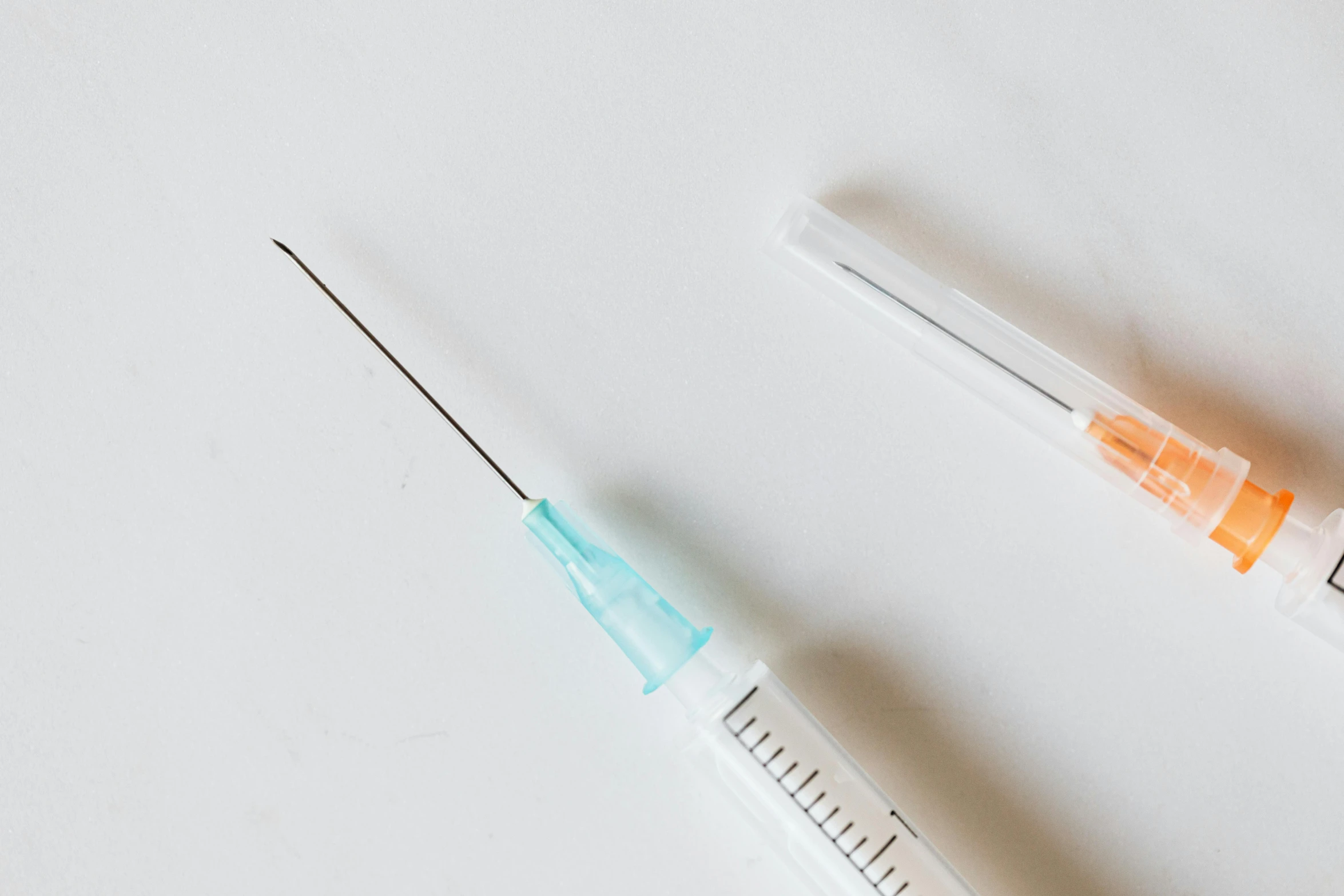 two sylls sitting next to each other on a table, by Matija Jama, unsplash, syringes, set against a white background, surgical impliments, background image