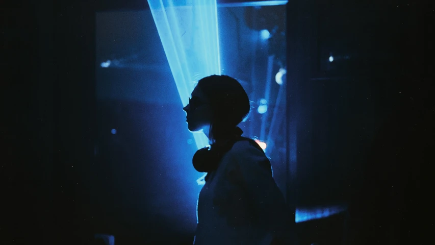a woman standing in front of a blue light, industrial party, instagram picture, underexposed, laser