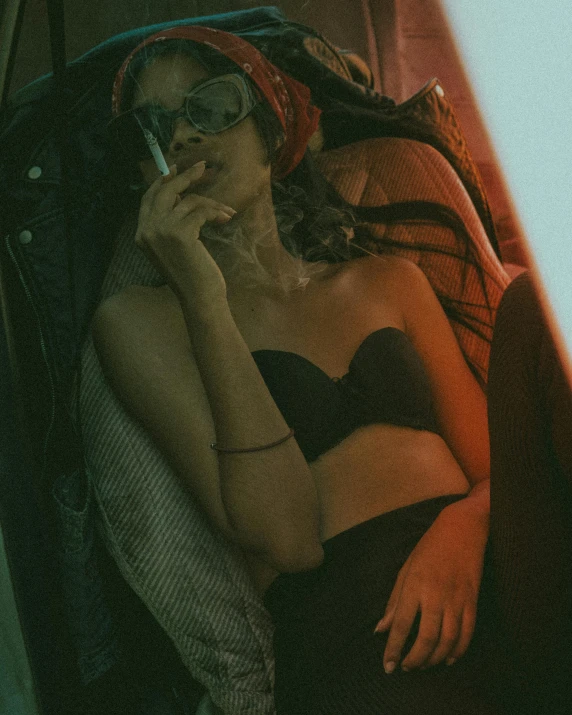 a woman sitting in a car talking on a cell phone, a polaroid photo, inspired by Elsa Bleda, trending on pexels, renaissance, in a black betch bra, smoke :6, woman smoking cigarette, dark shades