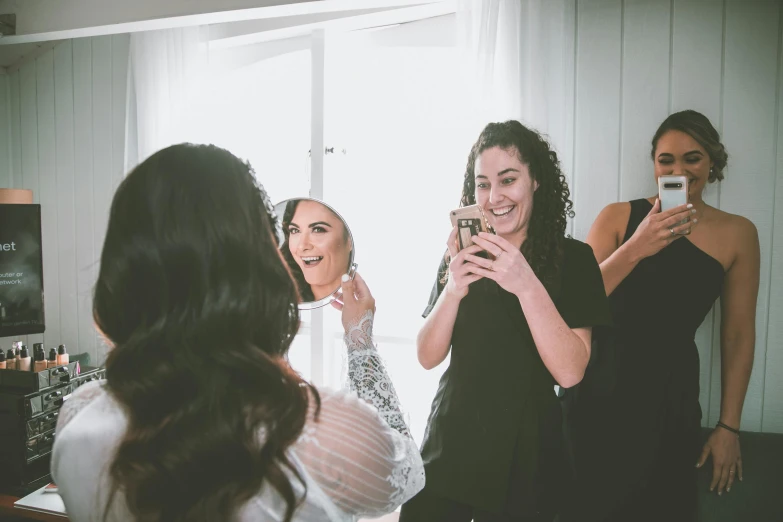 a group of women standing in front of a mirror, profile image, wedding photo, smiling down from above, both laughing