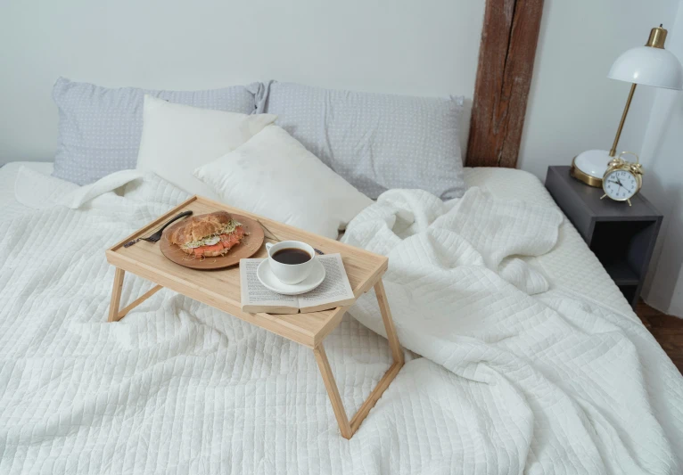 a bed with a tray of food and a cup of coffee, inspired by Constantin Hansen, white, small