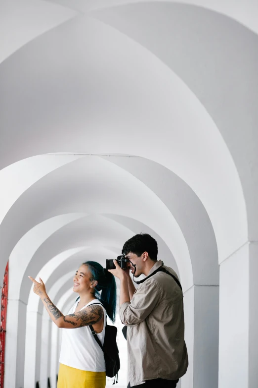 a man taking a picture of a woman with a camera, inspired by Luis Paret y Alcazar, pexels contest winner, visual art, arched ceiling, in front of white back drop, college, taiwan