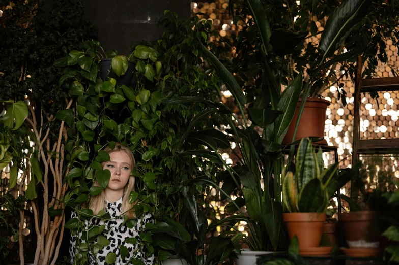 a woman standing in front of a bunch of plants, unsplash, photorealism, elle fanning), ignant, sydney sweeney, low-light photograph