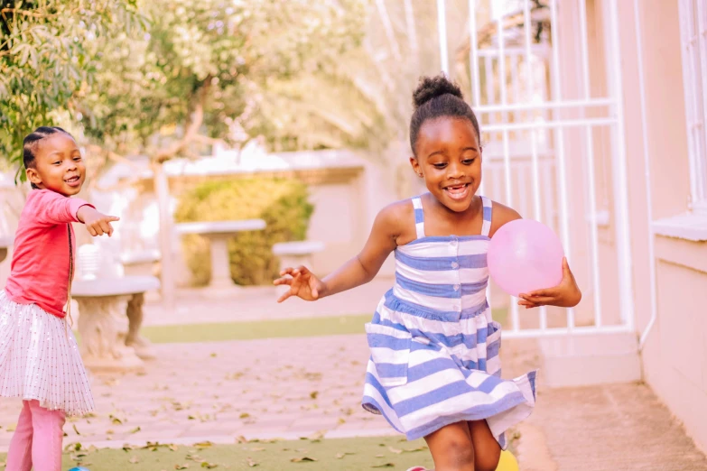 a couple of young girls playing a game of frisbee, by Lily Delissa Joseph, pexels contest winner, light skinned african young girl, holding a balloon, gardening, 5 years old