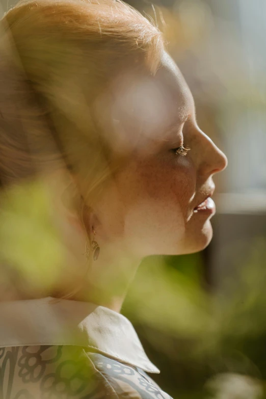 a close up of a person with a cell phone, by Anna Boch, diffuse natural sun lights, woman's profile, cinematic image, amongst foliage