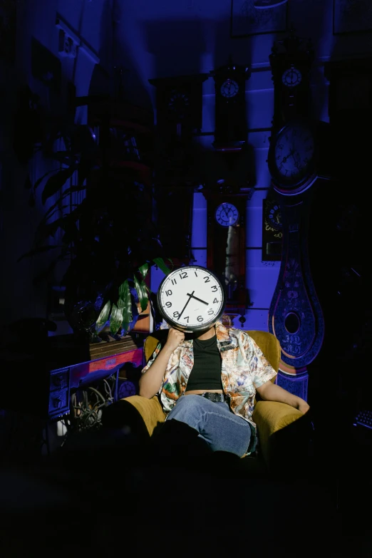 a man sitting in a chair with a clock on his head, unsplash, maximalism, nightlife, photo of a woman, taken in the late 2000s, rex orange county