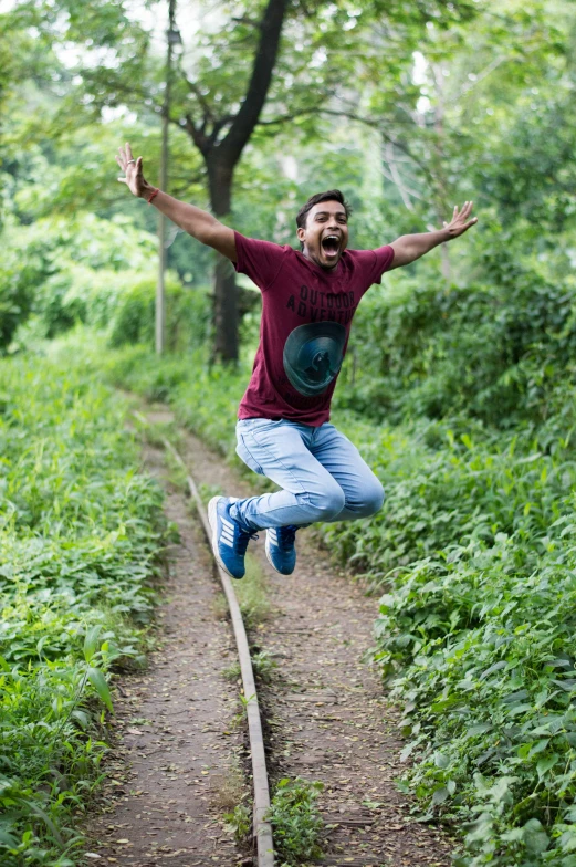 a man jumping in the air on a train track, inspired by Ismail Gulgee, happening, in jungle forest, happy face, at college, super technical