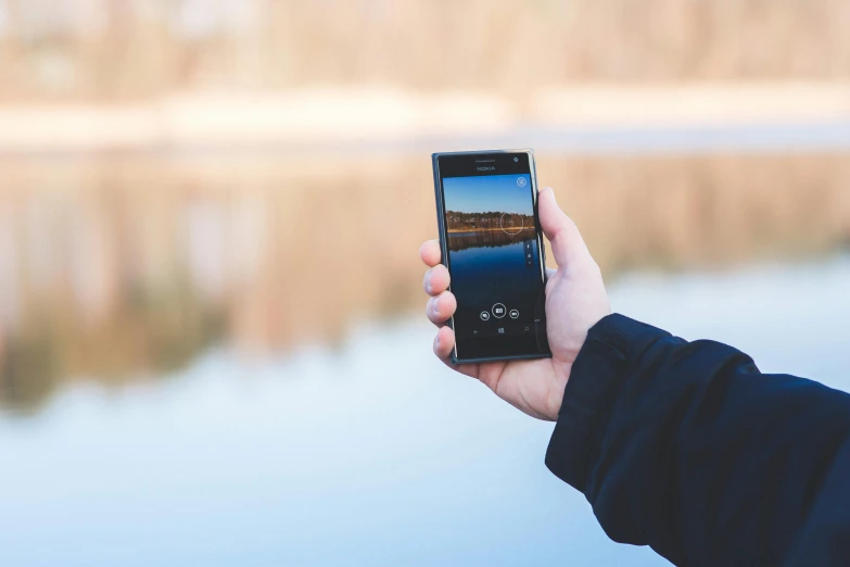 a person taking a picture of a lake with a cell phone, pexels contest winner, realism, android close to camera, detailed –n 9, medium portrait, with a sleek spoiler
