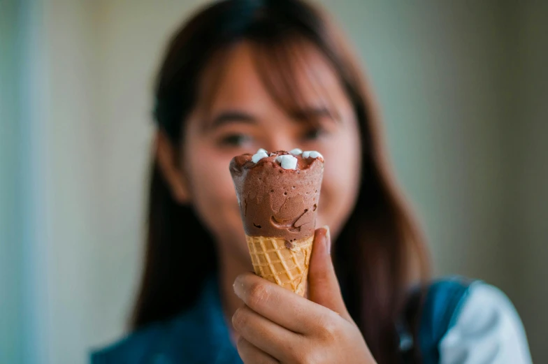 a close up of a person holding an ice cream cone, pexels contest winner, asian female, chocolate frosting, thumbnail, malaysian