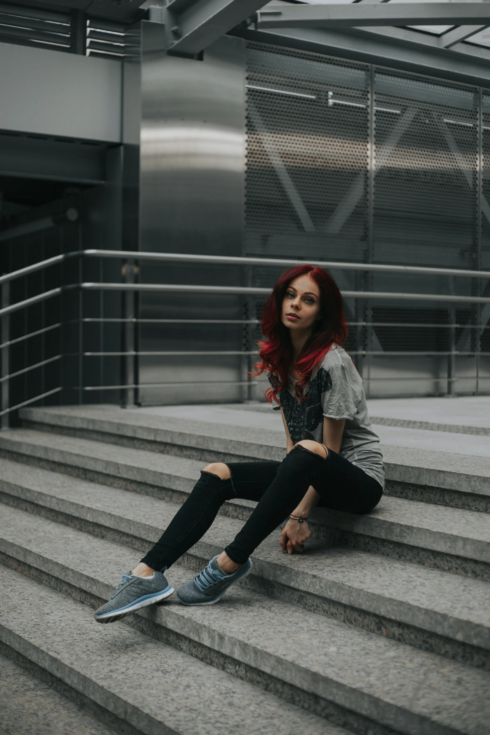 a woman sitting on the steps of a building, pexels contest winner, antipodeans, dark red hair, casual streetwear, gif, metallic red