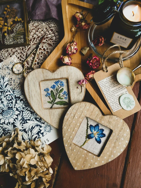 a wooden box sitting on top of a wooden table, a cross stitch, inspired by Sophie Pemberton, unsplash, heart made of flowers, beautiful frames, dried herbs, product introduction photo