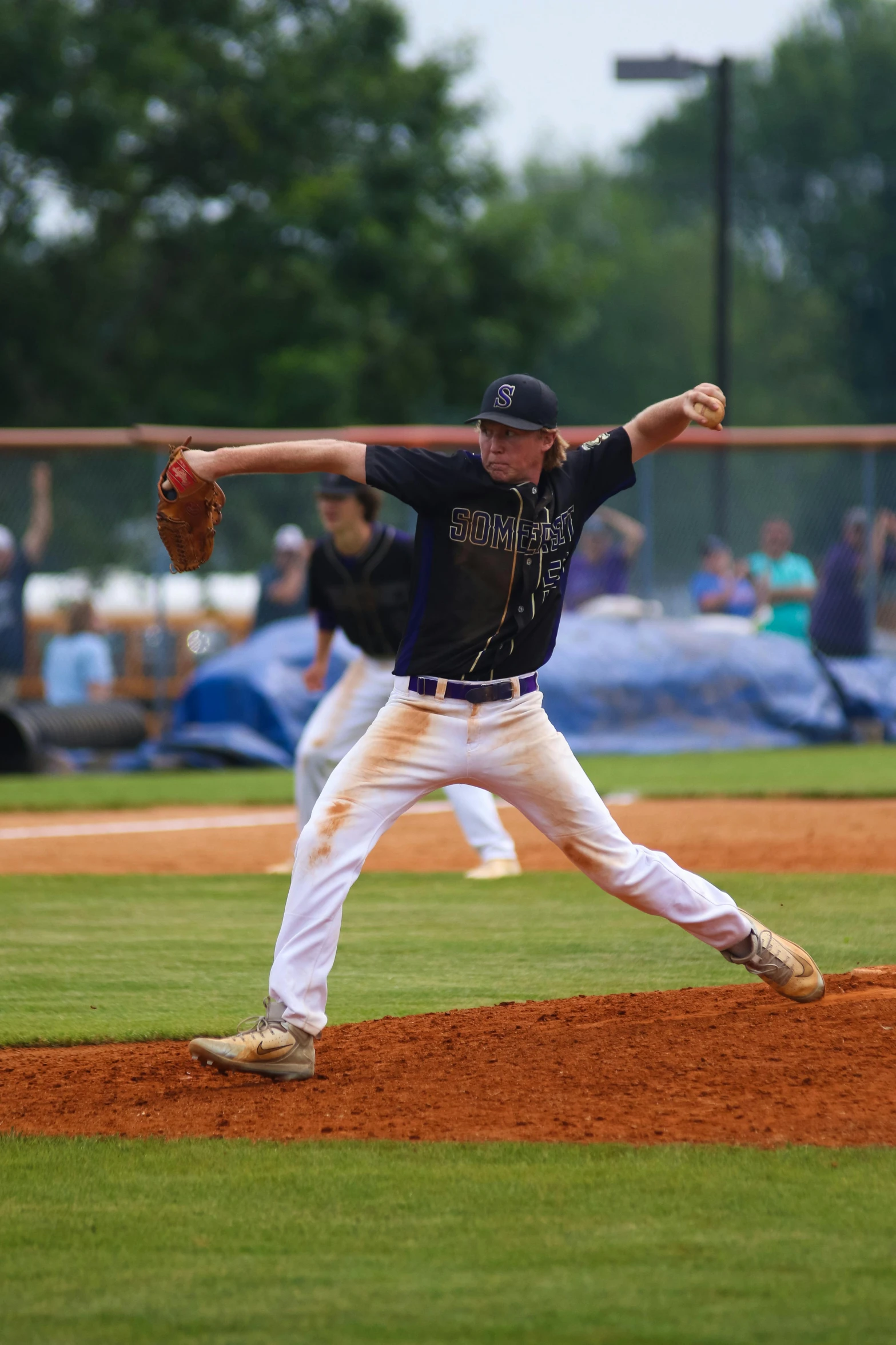 a man pitching a baseball on top of a field, purple, tyndall rays, tyler west, tournament