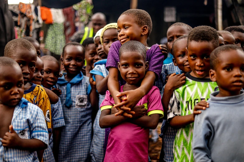 a group of children standing next to each other, by Daniel Lieske, pexels contest winner, hurufiyya, edward buba, thumbnail, holding close, smiling