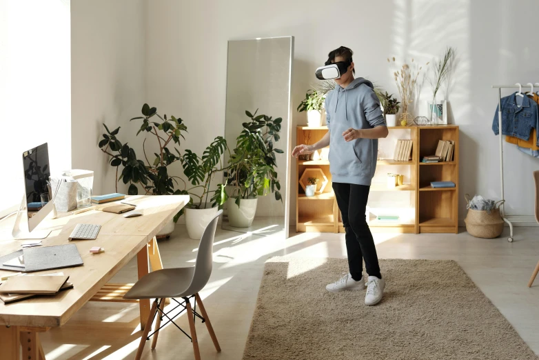 a woman standing in a living room playing a video game, a computer rendering, trending on pexels, light and space, a man wearing golden mask, in a open-space working space, augmented reality, erik johansson style