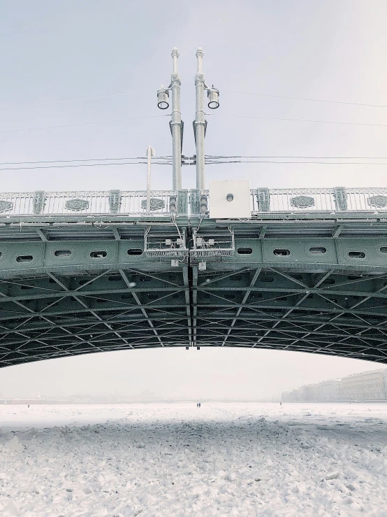 a bridge over a body of water covered in snow, in moscow centre, viewed from the ground, 🚿🗝📝, complex and desaturated