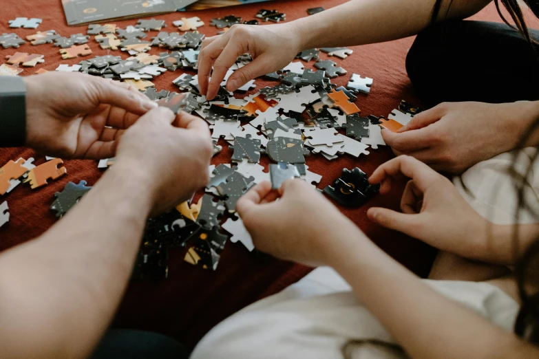 a group of people putting pieces of a puzzle together, by Adam Marczyński, pexels contest winner, 🦩🪐🐞👩🏻🦳, 64x64, family friendly, thorough details