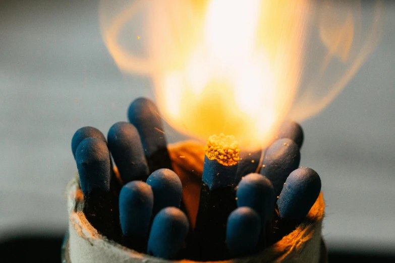 a close up of a bunch of matches, by Daniel Lieske, unsplash, auto-destructive art, gold and indigo, made of glowing wax and ceramic, cosy atmosphere, exterior shot