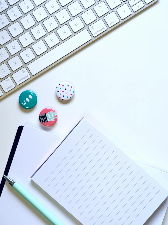 a notepad sitting on top of a desk next to a keyboard, by Arabella Rankin, buttons, 9 9 designs, high quality image