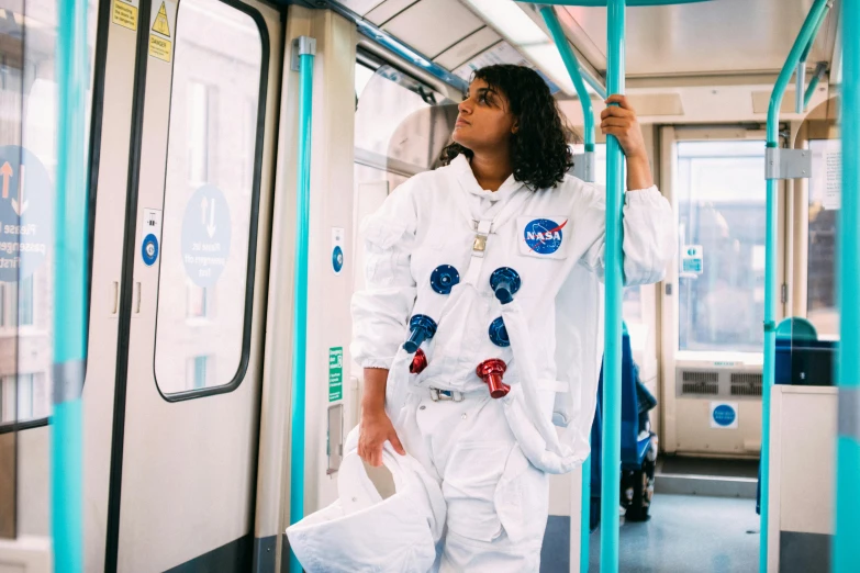 a woman in a space suit on a subway, by Helen Stevenson, trending on unsplash, imaan hammam, wearing lab coat and a blouse, lunar themed attire, lena oxton