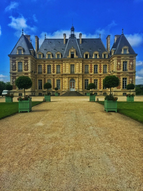 a large castle sitting on top of a lush green field, an album cover, by Raphaël Collin, pexels contest winner, ornate french architecture, 👰 🏇 ❌ 🍃, prefecture streets, exterior botanical garden