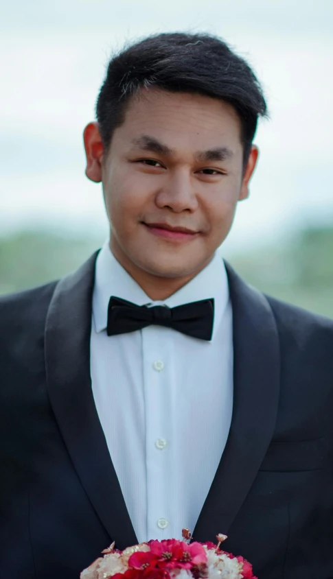 a man in a tuxedo holding a bouquet of flowers, by Robbie Trevino, south east asian with round face, graduation photo, 15081959 21121991 01012000 4k, manly