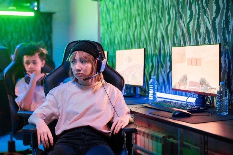 a little girl sitting in a chair in front of a computer, esports, profile image, colour corrected, person in foreground
