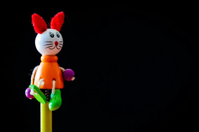 a toy rabbit sitting on top of a toothbrush, a child's drawing, pexels, figuration libre, standing with a black background, half wooden pinocchio, square, cat bunny