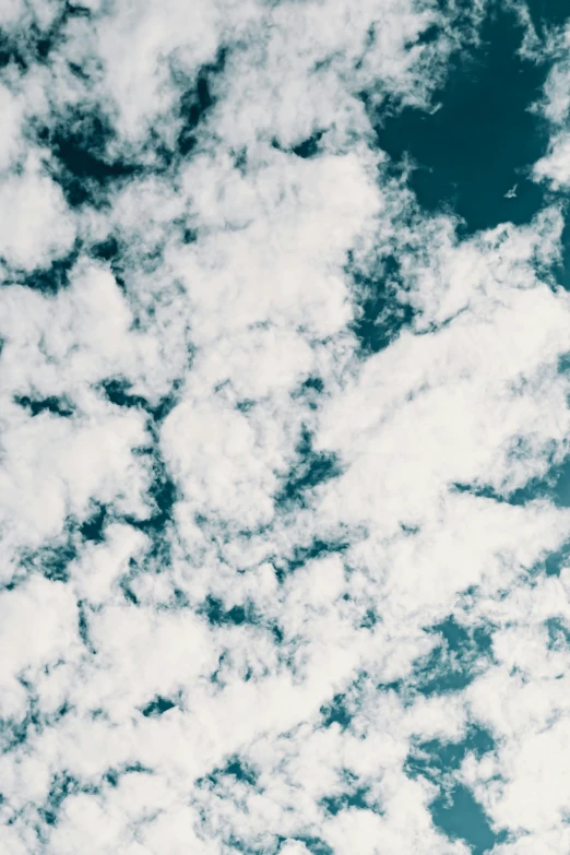 a plane flying through a cloudy blue sky, inspired by Elsa Bleda, trending on unsplash, cotton clouds, teal aesthetic, 2019 trending photo, portrait photo