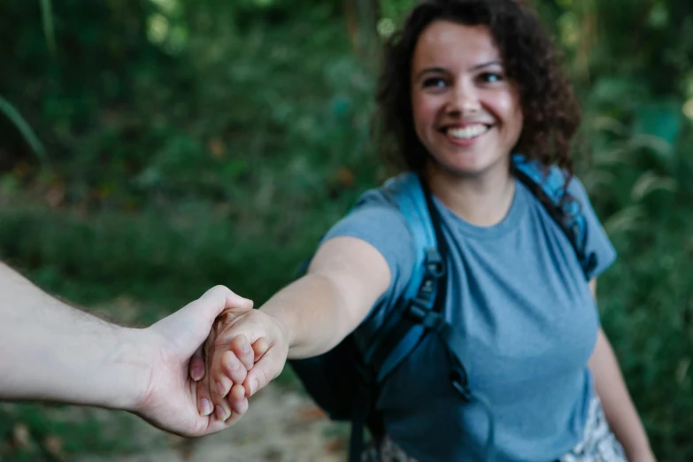 a close up of a person holding a person's hand, smiling into the camera, adventuring, avatar image, outdoor photo