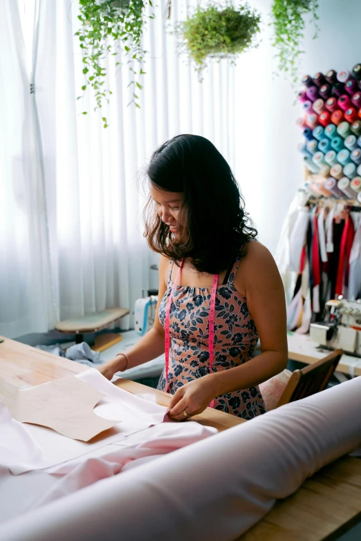 a woman standing in front of a sewing machine, wearing a crop top, carefully crafted, hoang lap, bedhead