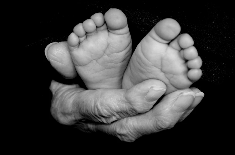a black and white photo of a person holding a baby's feet, dada, aging, beautiful artwork, happy toes, brian ingram