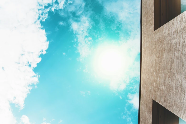 the sun shines brightly through the windows of a building, an album cover, pexels contest winner, light and space, light blue sky with clouds, view from bottom, summer sky, today\'s featured photograph 4k