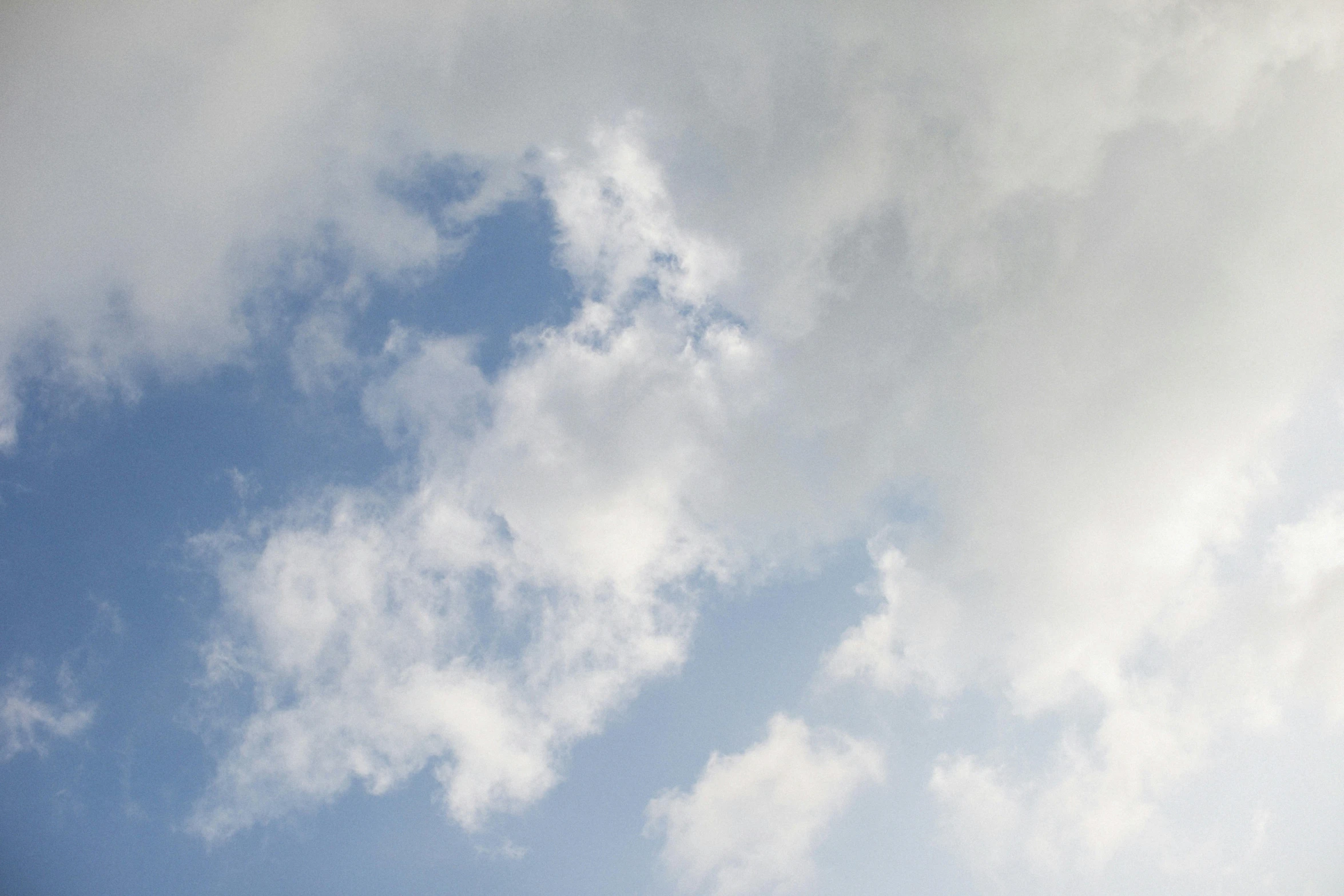 a person is flying a kite in the sky, unsplash, minimalism, layered stratocumulus clouds, high res photograph, low-angle, cumulus