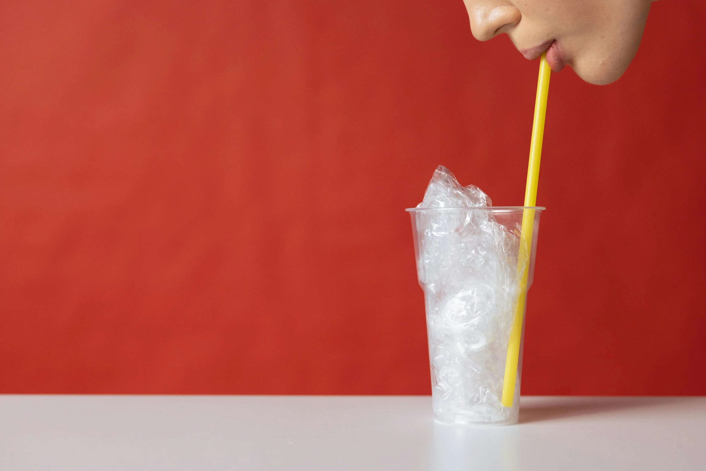 a child drinking from a plastic cup with a straw, trending on pexels, hyperrealism, close up of single sugar crystal, woman, minimalistic composition, facing sideways