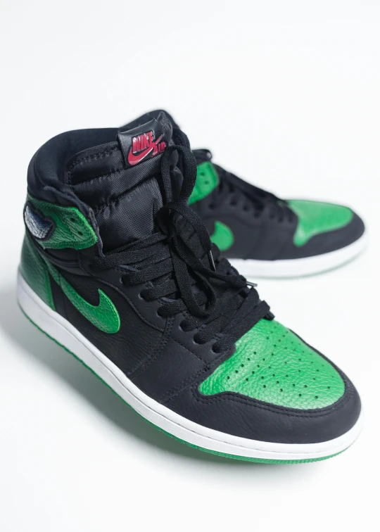 a pair of black and green sneakers on a white surface, an album cover, trending on unsplash, air jordan 1 high, detailed color scan, front side view full sheet, sold at an auction