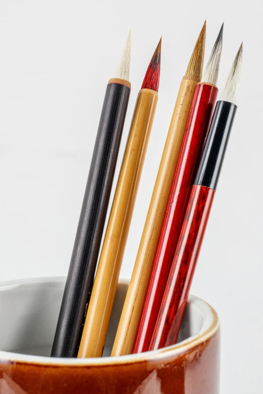 a cup that has some pencils in it, a portrait, inspired by Kanō Shōsenin, pexels, demur, close-up product photo, cranes, payne's grey and venetian red